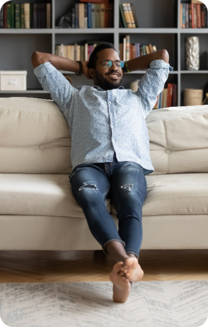 A man relaxes on a couch, smiling